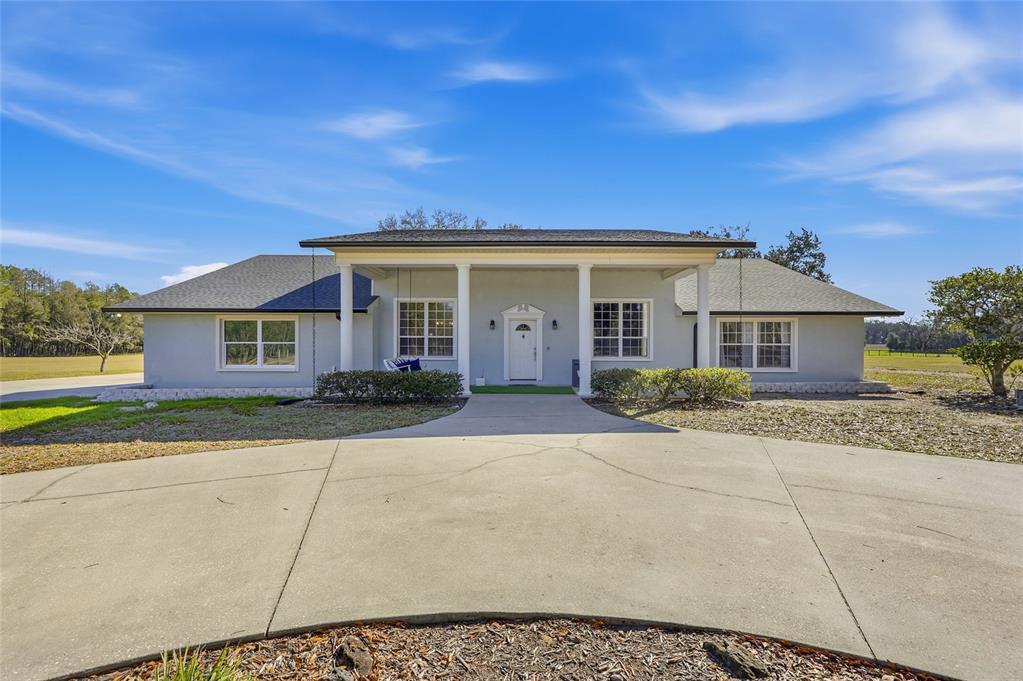 A single-story house with a covered front porch and a concrete driveway — 9115 NW 170TH STREET, ALACHUA, FL