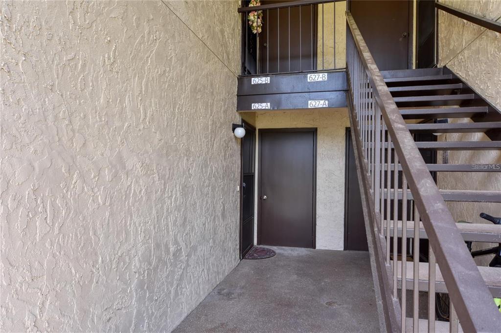 An exterior view shows a ground-level apartment entrance and a staircase leading to upper units — 625 MIDWAY DRIVE UNIT A, OCALA, FL