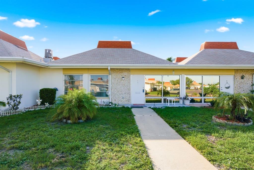 A single-story house with a white door, stone facade, and a hip roof — 4344 TAHITIAN GARDENS CIRCLE UNIT B, HOLIDAY, FL