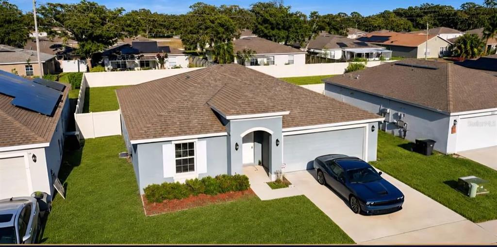 An aerial view of a single-story house with a gray exterior, brown roof, and driveway — 3417 YARIAN DRIVE, HAINES CITY, FL
