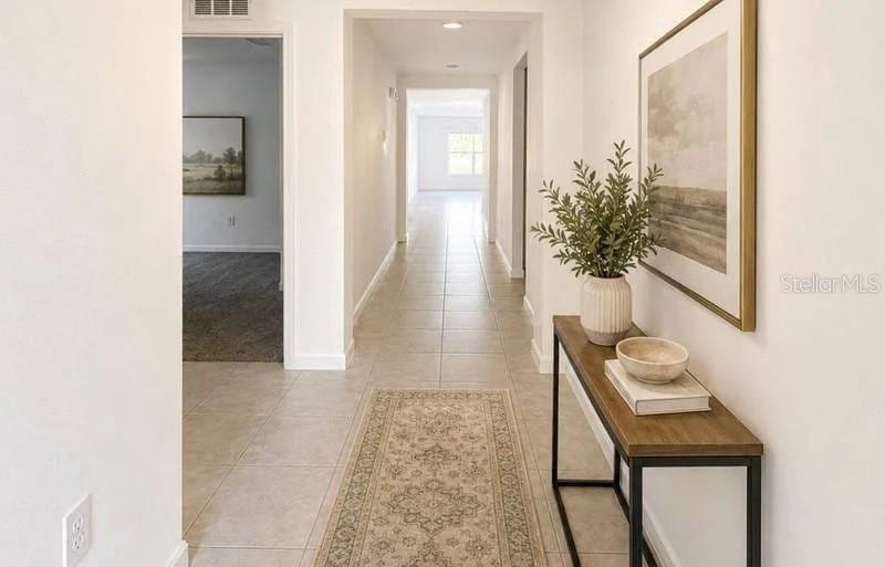 A hallway with tile flooring, a runner rug, and a console table against the wall — 3417 YARIAN DRIVE, HAINES CITY, FL