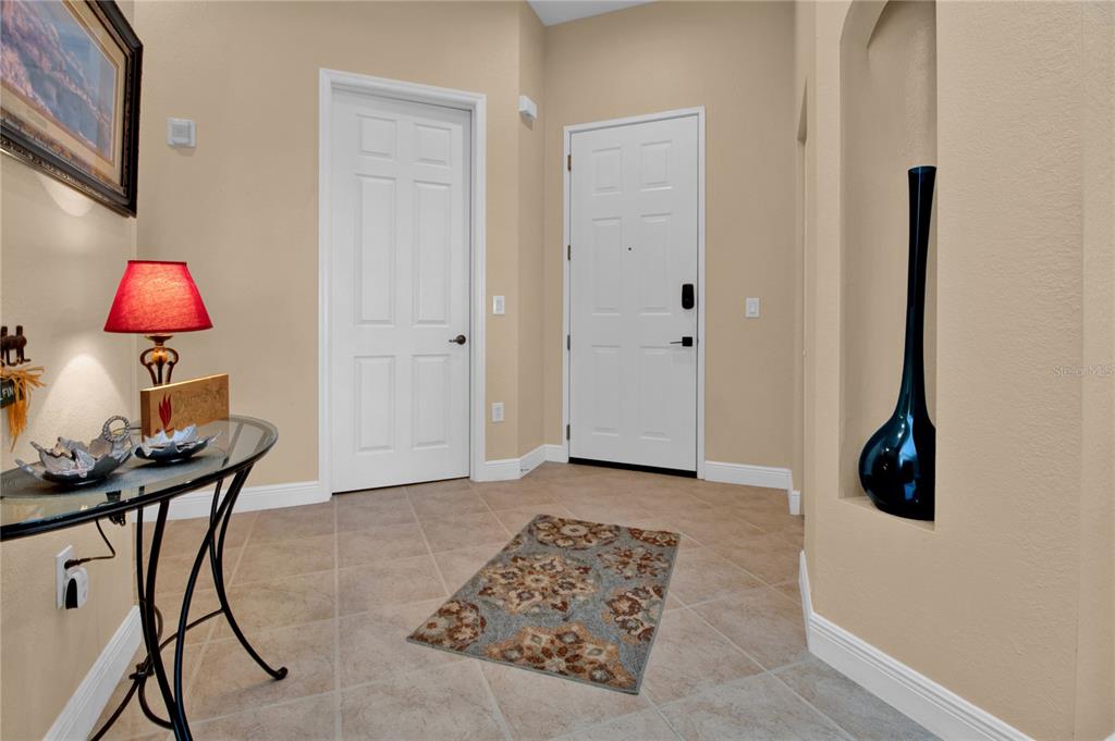 An entryway features tile flooring, a white front door, a console table, and a wall niche — 24417 BALTIC AVENUE UNIT 1302, PUNTA GORDA, FL