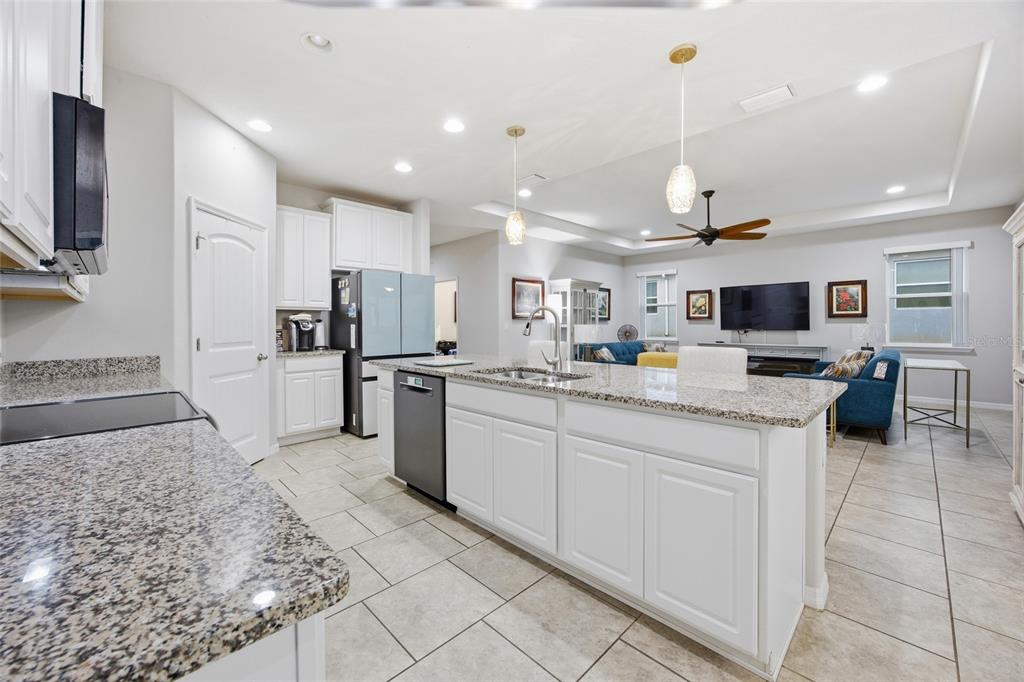 An empty bedroom features light gray walls, wood-look tile flooring, two windows, and a ceiling fan — 5626 SW 50TH COURT, OCALA, FL