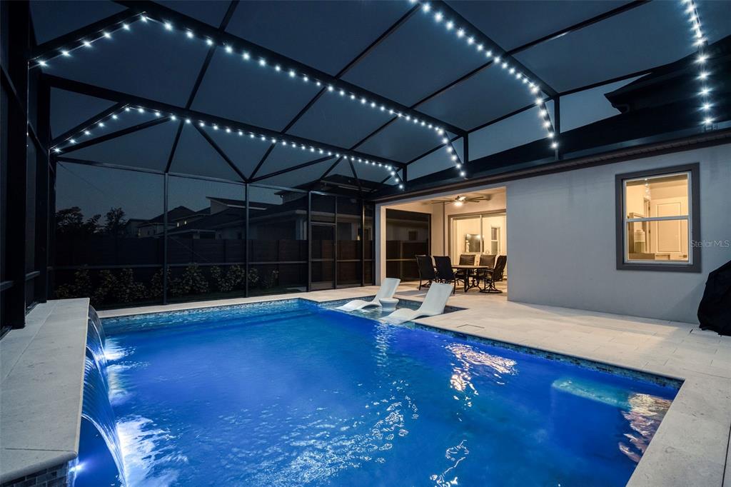 A screened-in patio features a swimming pool with lounge chairs and a covered dining area — 13175 MCMILLAN, ORLANDO, FL