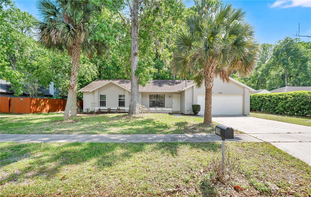 A single-story house with a two-car garage, palm trees, and a front lawn — 709 SAILFISH ROAD, WINTER SPRINGS, FL