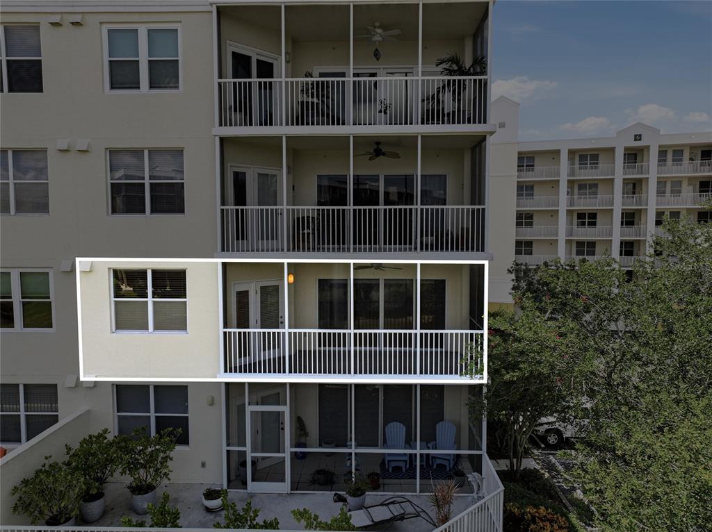 An exterior view of a multi-story apartment building featuring screened-in balconies and white railings — 1200 COUNTRY CLUB DRIVE UNIT 4201, LARGO, FL