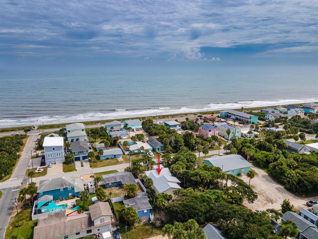 An aerial view shows a coastal neighborhood with a red arrow pointing to a house — 1512 S CENTRAL AVENUE, FLAGLER BEACH, FL
