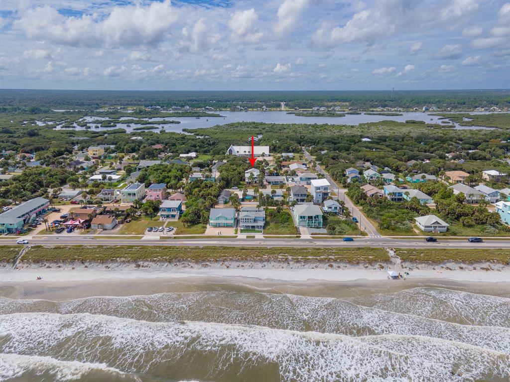 An aerial view shows a coastal neighborhood with a house highlighted by a red arrow — 1512 S CENTRAL AVENUE, FLAGLER BEACH, FL