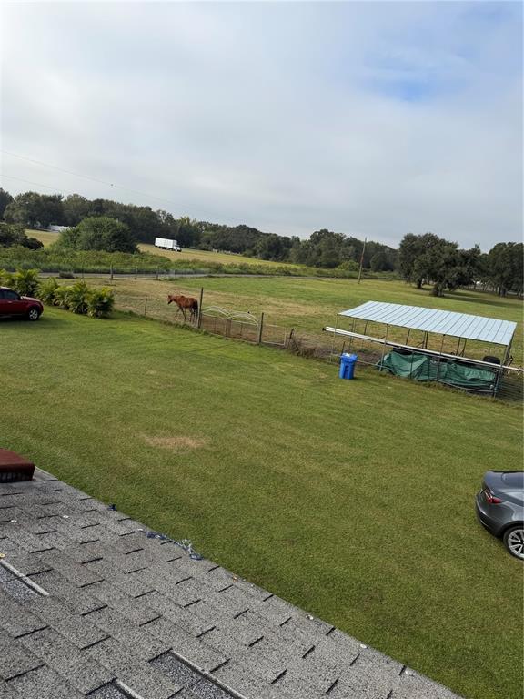 An elevated view of a grassy yard with a horse, a metal carport, and vehicles — 14626 MCGRADY ROAD, WIMAUMA, FL