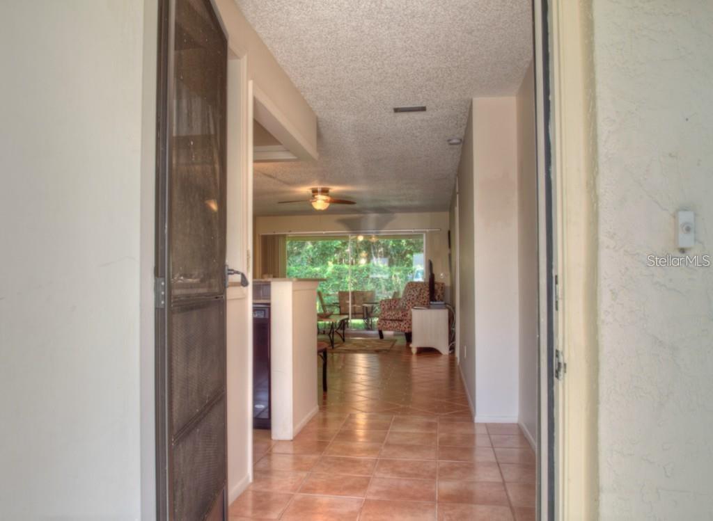 A view through an open doorway into a tiled living area with a ceiling fan — 7062 W COUNTRY CLUB DRIVE N UNIT 7062, SARASOTA, FL