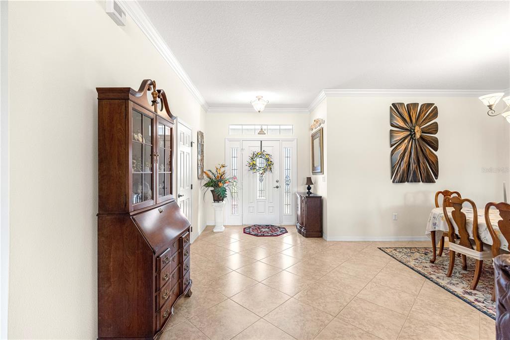 A spacious foyer with tile flooring leads to a white front door with sidelights — 8355 SW 84TH LOOP, OCALA, FL