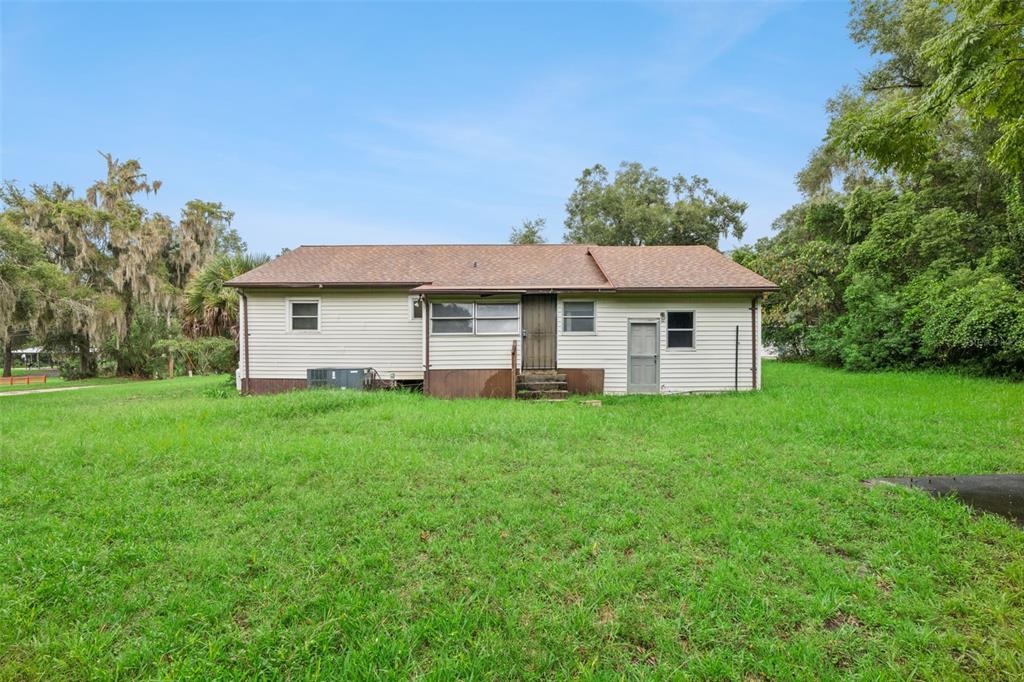 A single-story house with light-colored siding and a brown shingled roof sits on a lawn — 381 W OHIO AVENUE, LAKE HELEN, FL