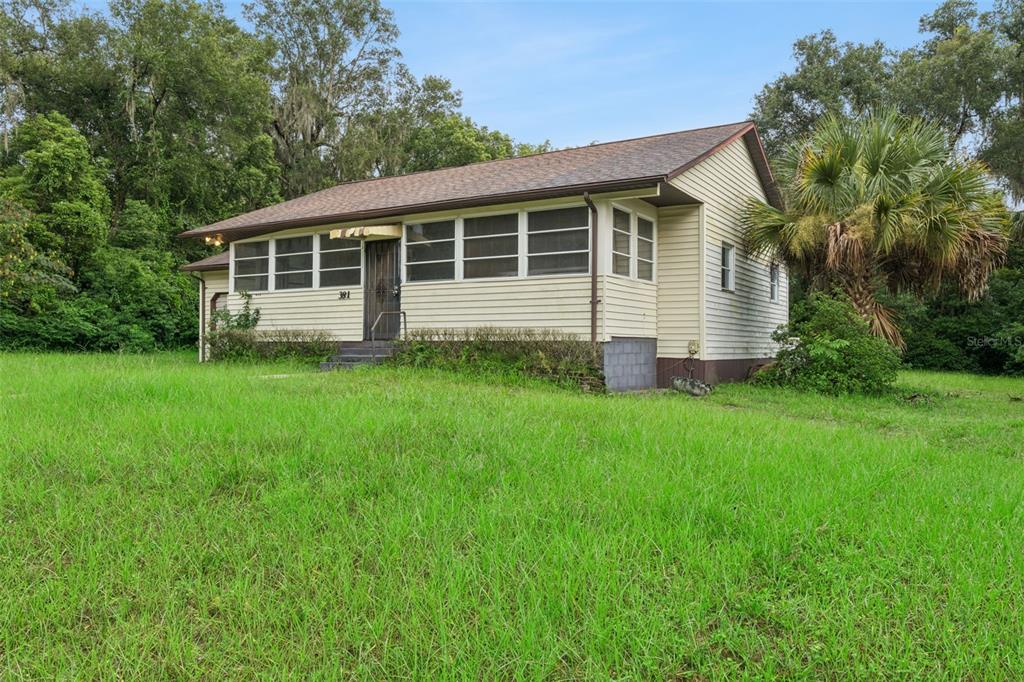 A single-story house with light-colored siding, a brown roof, and a large grassy yard — 381 W OHIO AVENUE, LAKE HELEN, FL