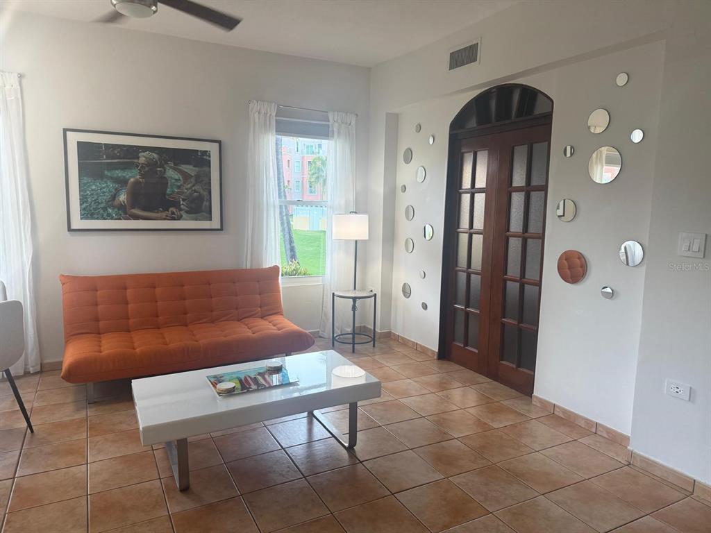 A living room features an orange sofa, white coffee table, and a wall with circular mirrors — 170 Candelero Dr, PALMAS DEL MAR, LAS PALMAS DORADAS, HUMACAO, PR