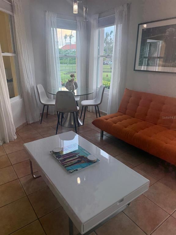 A living and dining area features a white coffee table, orange sofa, and glass table — 170 Candelero Dr, PALMAS DEL MAR, LAS PALMAS DORADAS, HUMACAO, PR