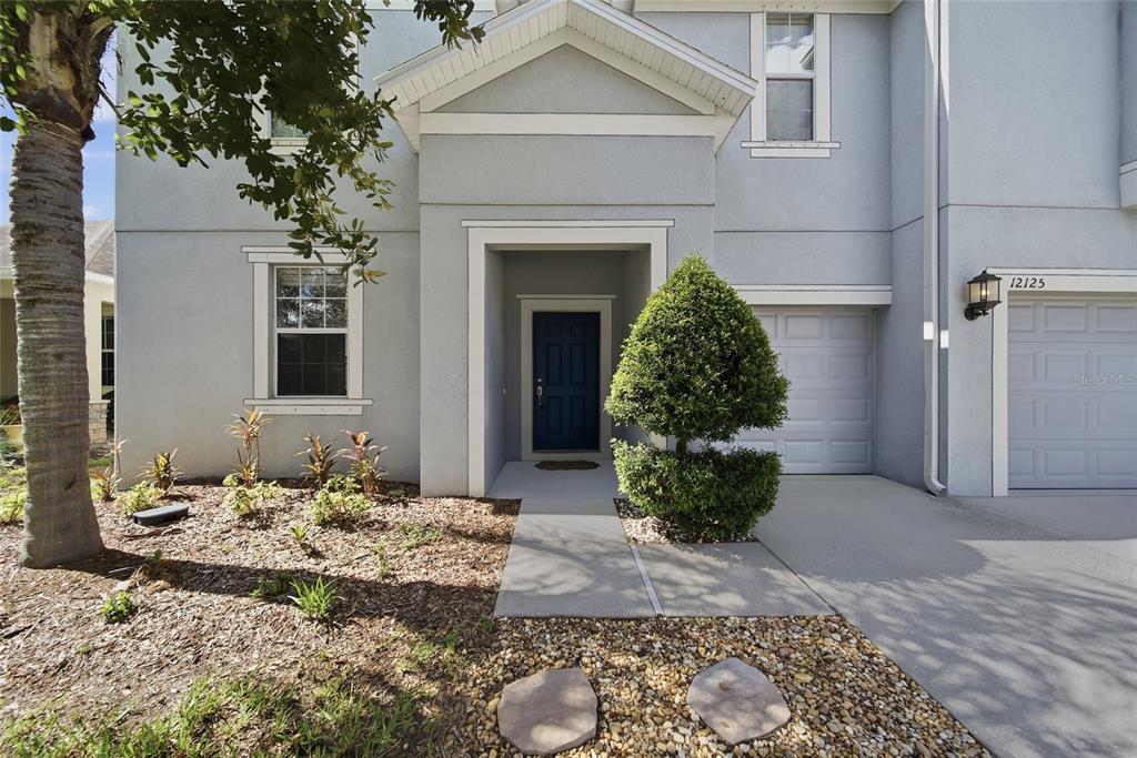 A light gray two-story house features a dark blue front door and a single-car garage — 12125 STREAMBED DRIVE, RIVERVIEW, FL