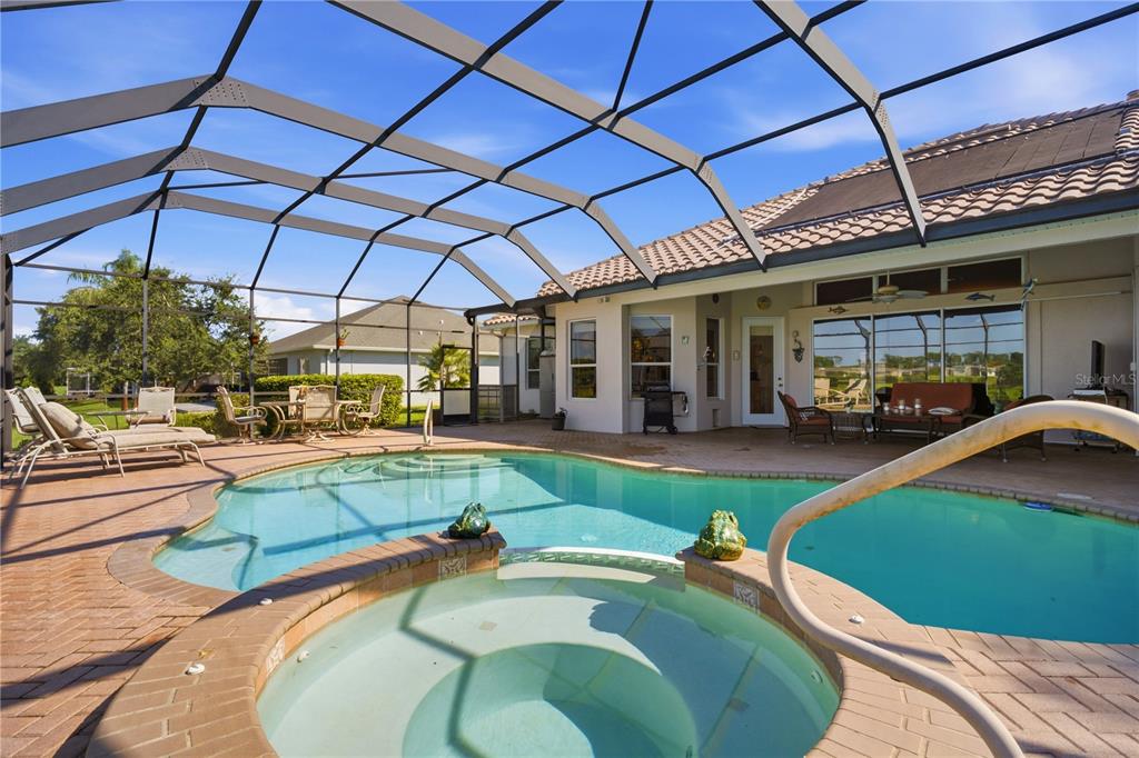 A screened-in patio features a swimming pool, a hot tub, and outdoor furniture — 9271 WESTSHORE DRIVE, WEEKI WACHEE, FL