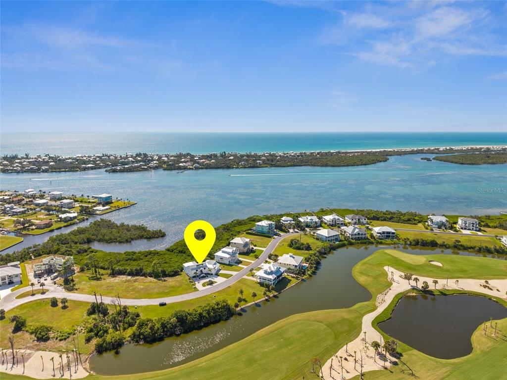 An aerial view shows a coastal residential neighborhood with a golf course and water — 10101 EAGLE PRESERVE DRIVE, ENGLEWOOD, FL