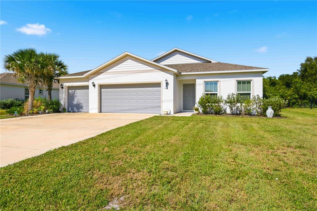 A single-story house with a three-car garage, a concrete driveway, and a front lawn — 403 SEASONS DRIVE, PUNTA GORDA, FL