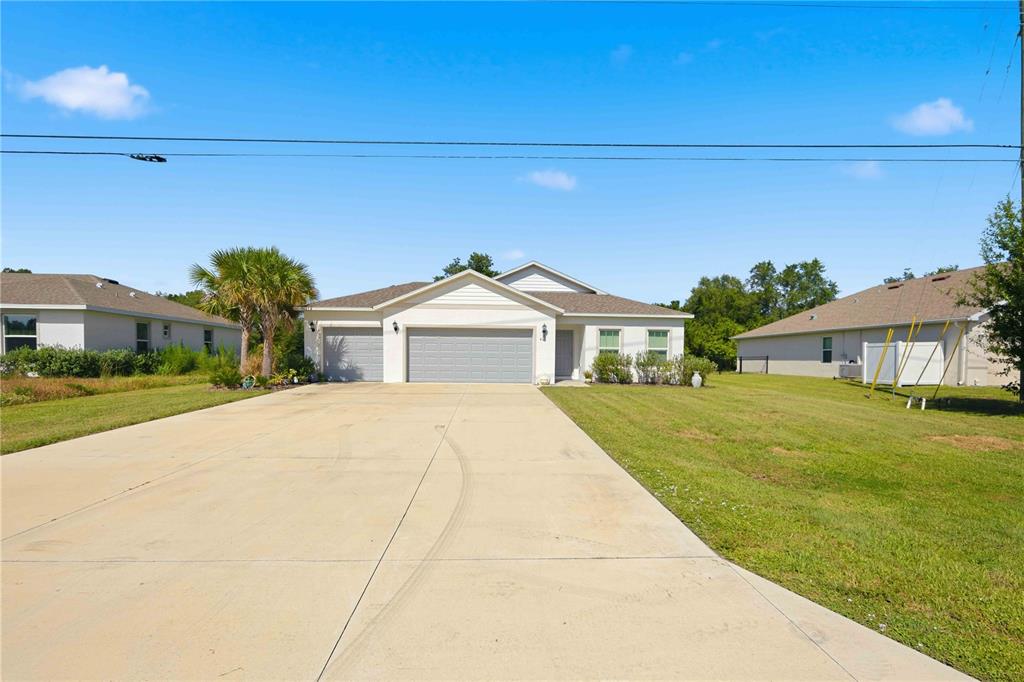 A single-story house with a three-car garage and a large concrete driveway — 403 SEASONS DRIVE, PUNTA GORDA, FL