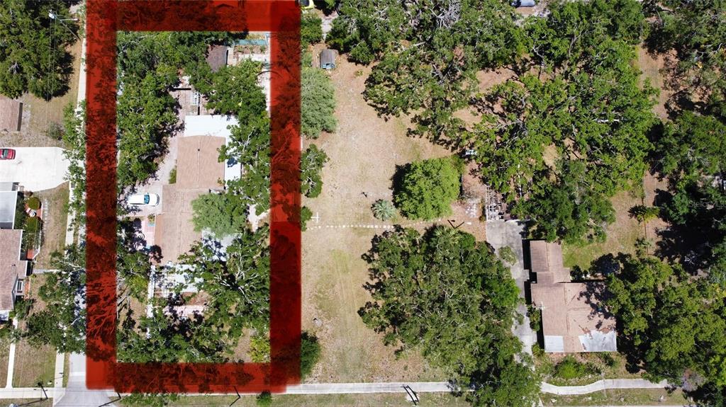 An aerial view shows a house highlighted in red next to a large vacant lot — 5680 77TH AVENUE N, PINELLAS PARK, FL