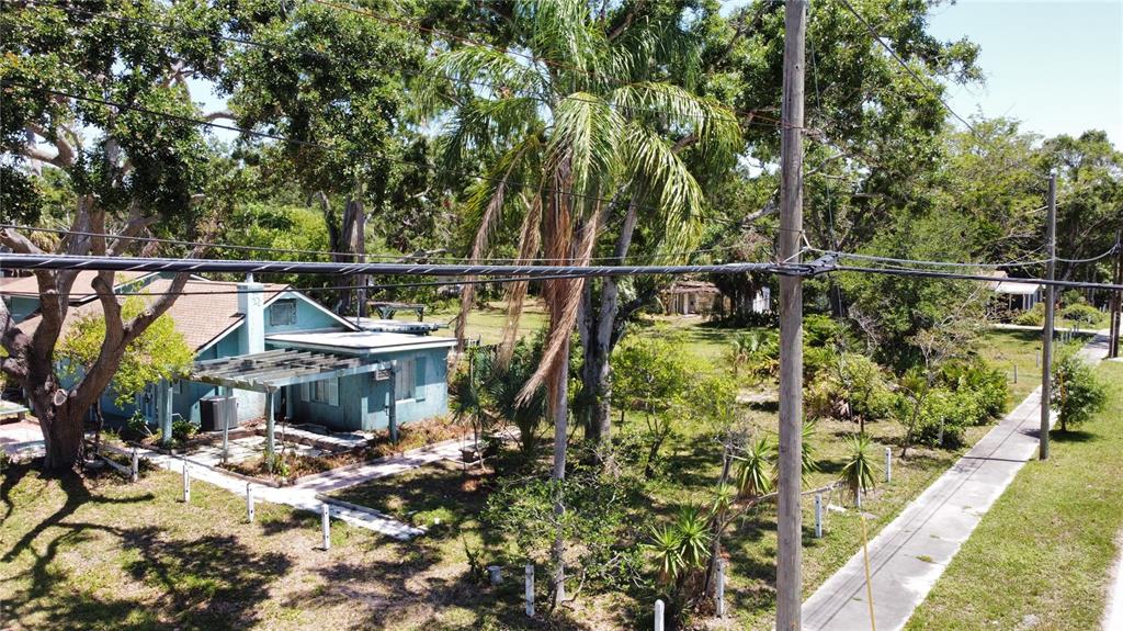 An aerial view of a light blue house with a pergola and surrounding trees — 5680 77TH AVENUE N, PINELLAS PARK, FL