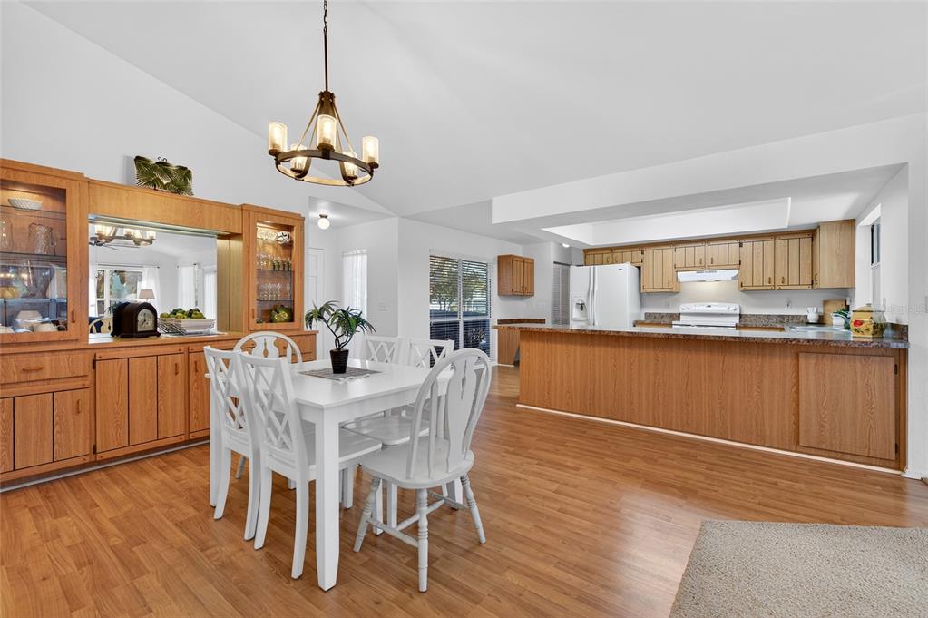 A dining area with a white table and chairs sits adjacent to an open kitchen — 236 MEADOW LAKE DRIVE, EDGEWATER, FL
