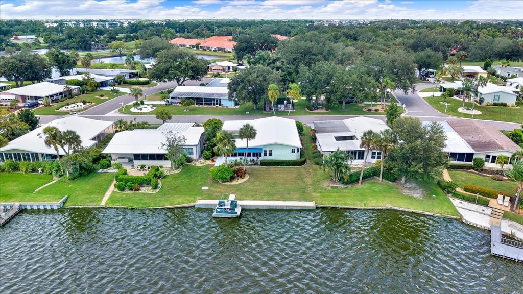 An aerial view shows several waterfront homes with private docks along a lake — 8479 IMPERIAL CIRCLE, PALMETTO, FL