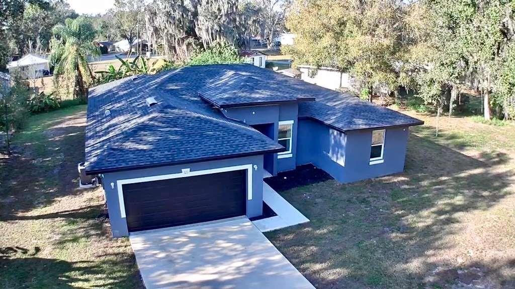 An aerial view of a single-story blue house with a dark shingled roof and garage — 121 ARGYLE AVENUE, FROSTPROOF, FL