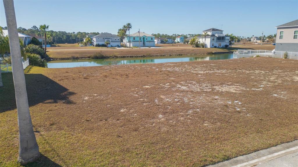 An elevated view of a vacant, grassy residential lot bordering a small canal — 3488 TRIGGERFISH DRIVE, HERNANDO BEACH, FL