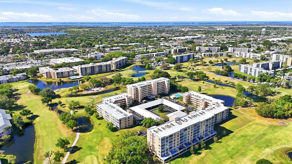 An aerial view shows multiple apartment buildings situated on a golf course with several ponds — 4460 FAIRWAYS BOULEVARD UNIT 302, BRADENTON, FL