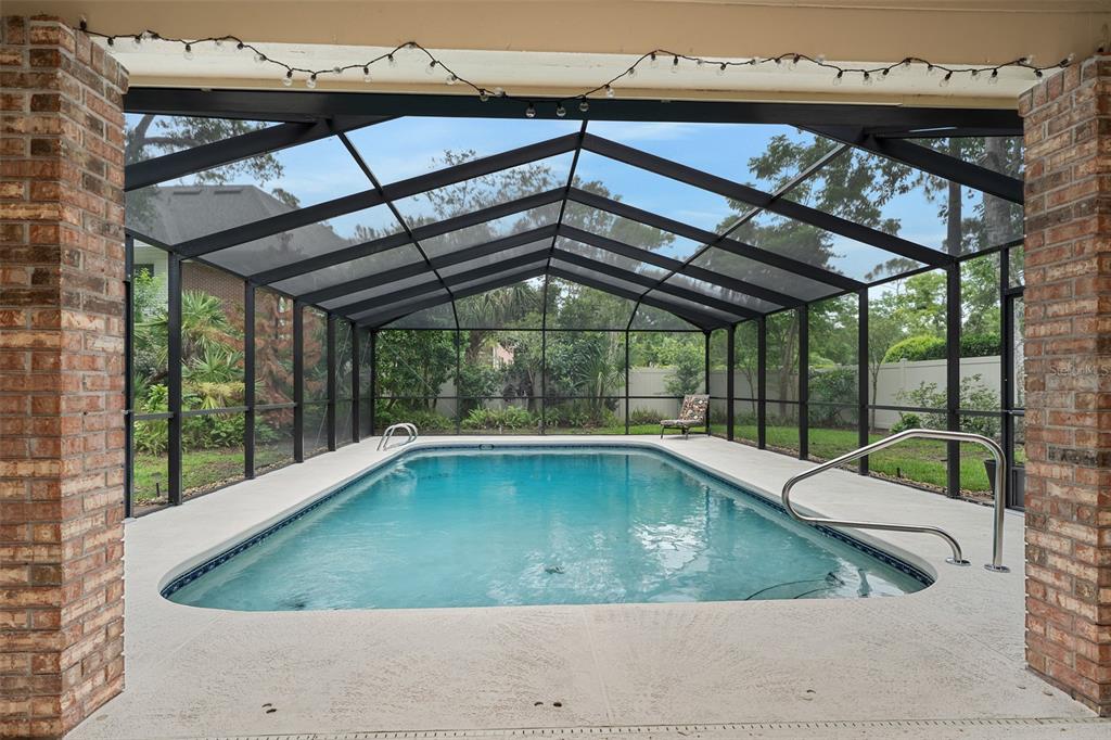 A two-story house with tan siding and brick exterior sits on a grassy lawn — 1 CROOKED BRIDGE WAY, ORMOND BEACH, FL