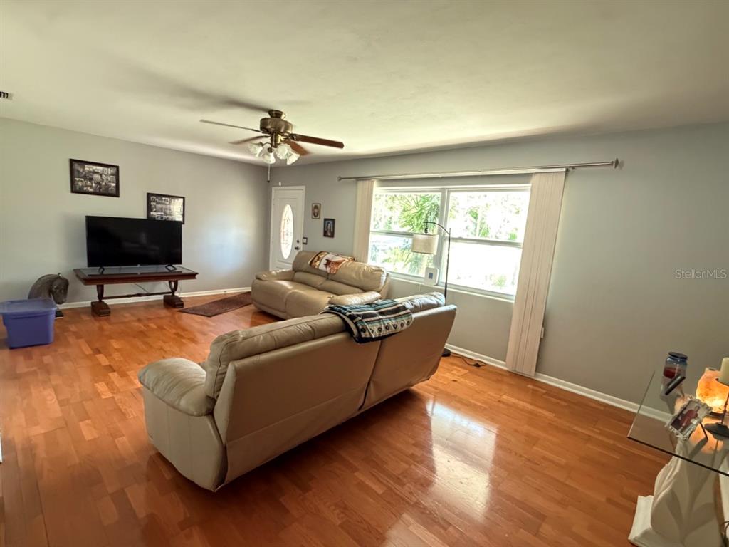 The exterior of a single-story house features a front door, garage, and landscaping — 1513 S KEENE ROAD, CLEARWATER, FL