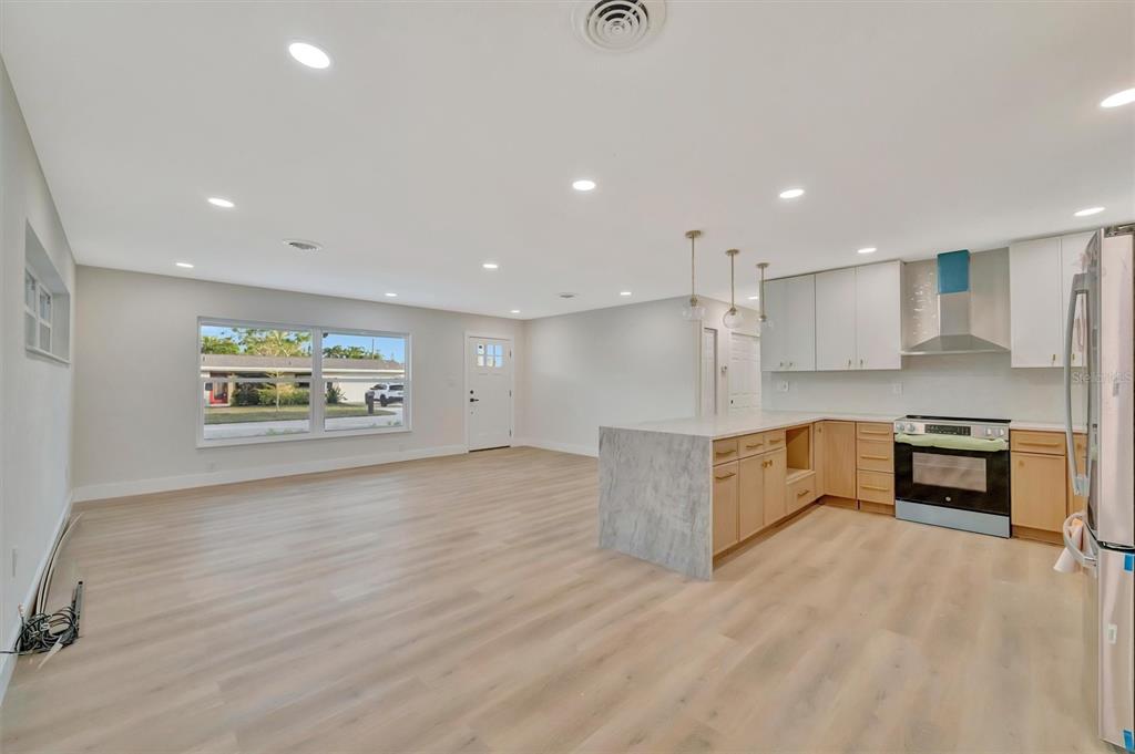 A white single-story house with a concrete driveway and a covered carport — 2705 SUNNYSIDE STREET, SARASOTA, FL