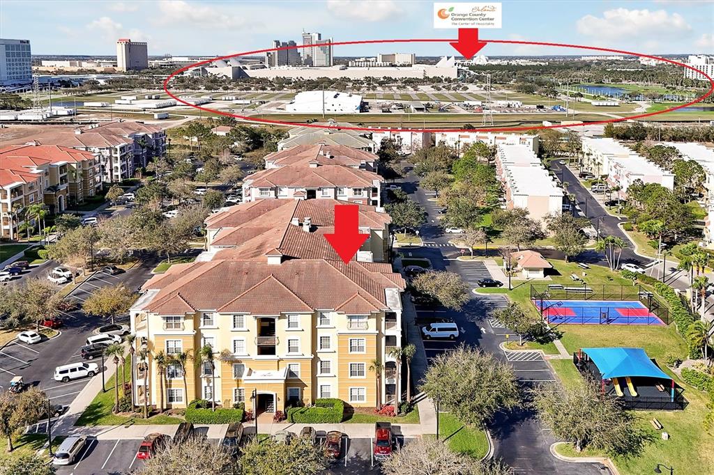 An aerial view shows a multi-story apartment complex with a nearby convention center in distance — 5025 SHOREWAY LOOP UNIT 30403, ORLANDO, FL