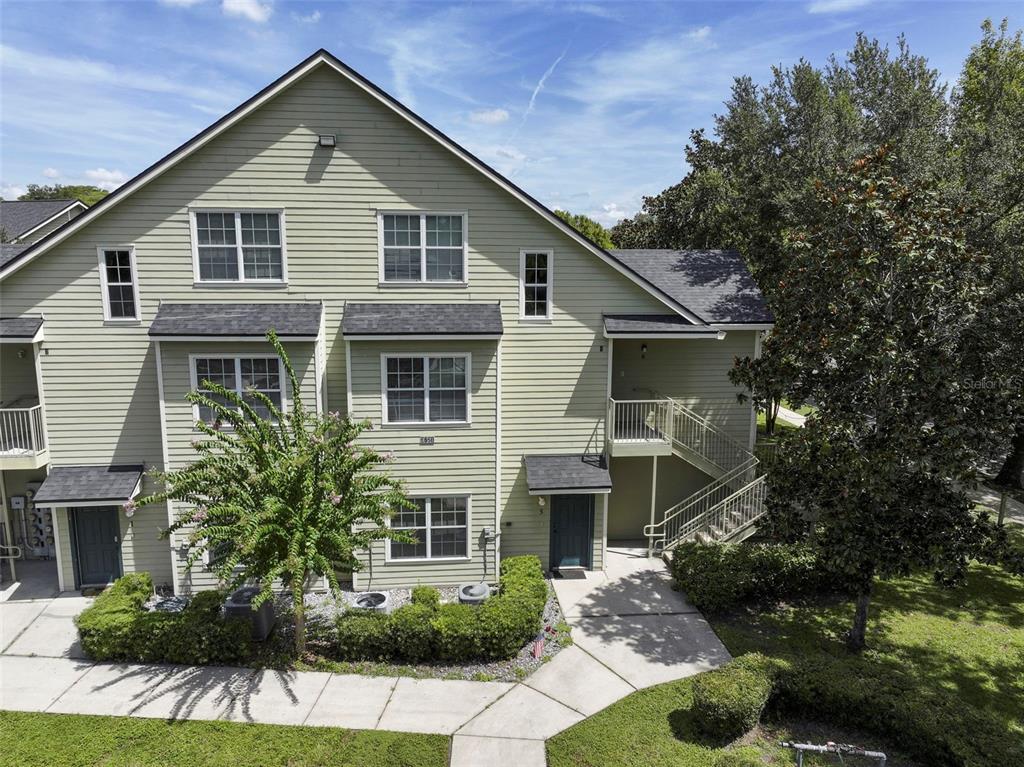 A three-story light green siding townhouse with a staircase leading to a second-floor entrance — 3721 S LAKE ORLANDO PARKWAY UNIT 6, ORLANDO, FL