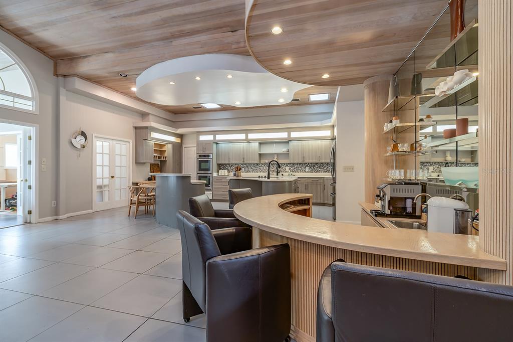 A kitchen and bar area featuring a curved counter, wood ceiling, and gray cabinetry — 101 N ST ANDREWS DRIVE, ORMOND BEACH, FL