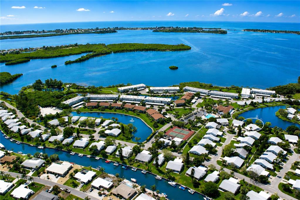 Aerial view of a waterfront residential community with canals, swimming pools, and tennis courts — 9425 ANDOVER CIRCLE, BRADENTON, FL
