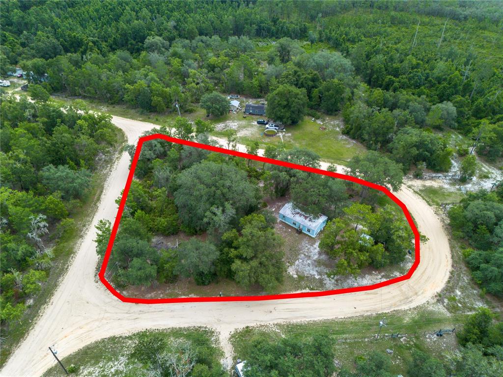 A small metal storage shed sits among trees with two kayaks stored on its side — 108 KITTY AVENUE, INTERLACHEN, FL