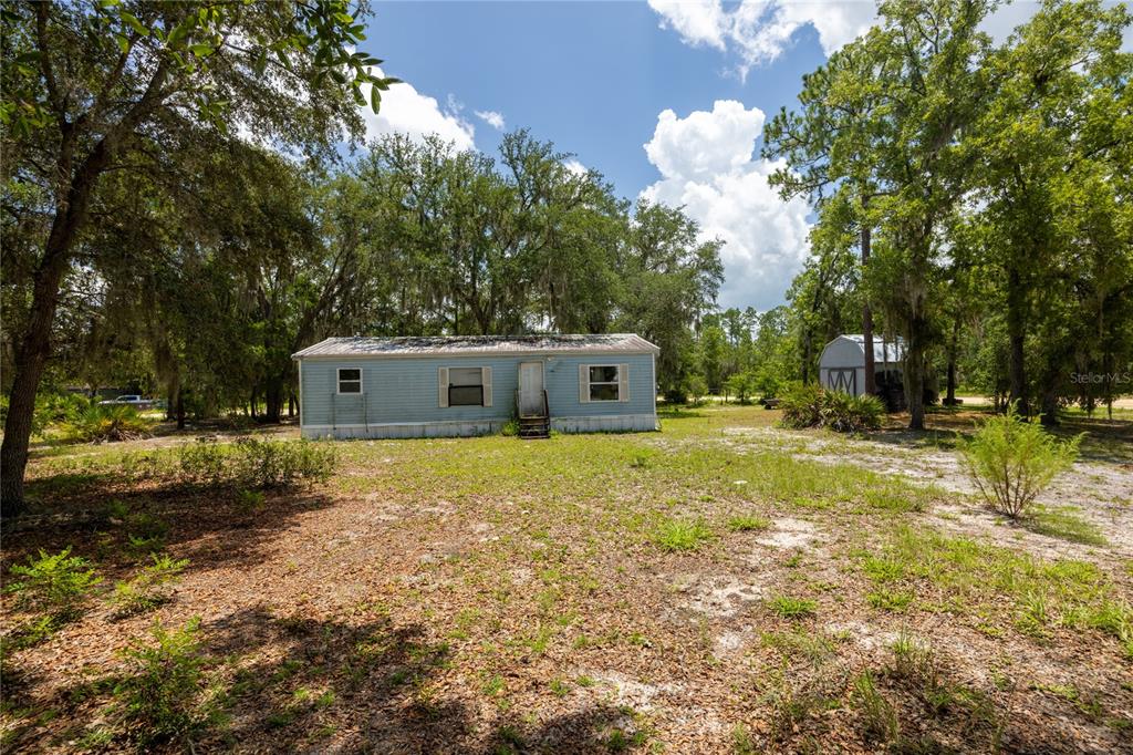 A kitchen area features a double sink, upper cabinets, and a stacked washer and dryer — 108 KITTY AVENUE, INTERLACHEN, FL