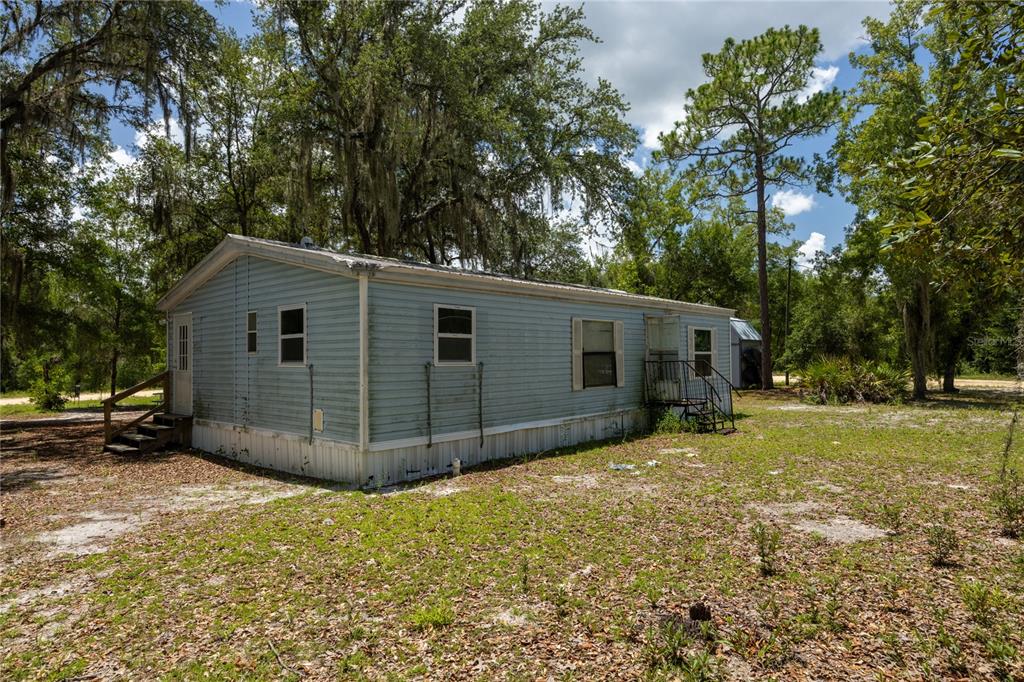 A kitchen features white cabinets with stickers, a gas range, and a stainless steel espresso machine — 108 KITTY AVENUE, INTERLACHEN, FL