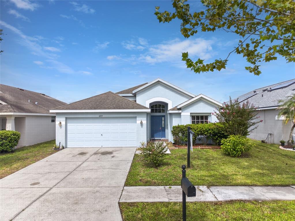An entryway with beige tile flooring, a white front door, and an arched hallway — 6833 RUNNER OAK DRIVE, ZEPHYRHILLS, FL