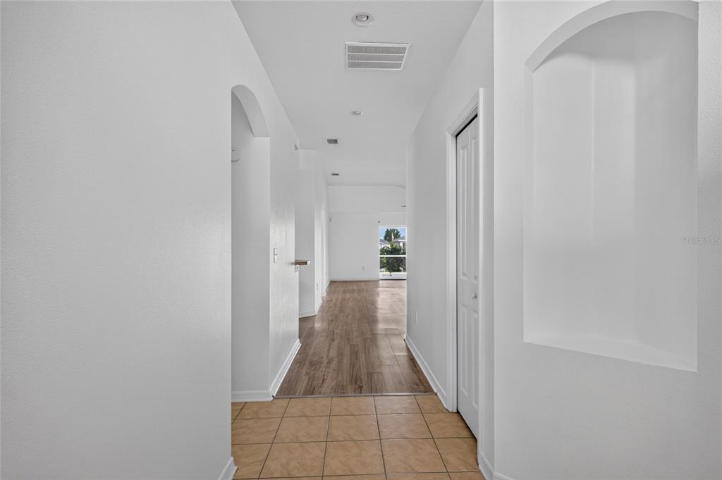 An empty bedroom features white walls, dark wood-look flooring, a ceiling fan, and a window — 6833 RUNNER OAK DRIVE, ZEPHYRHILLS, FL
