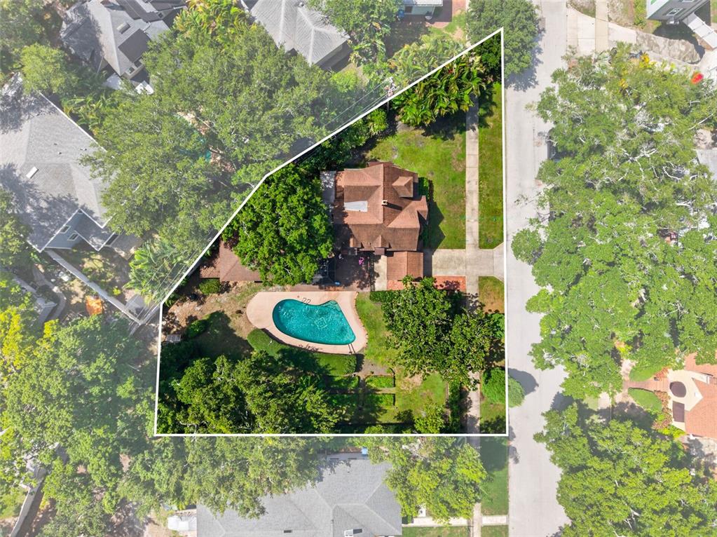 An aerial view shows a house with a swimming pool and trees on a lot — 2321 14TH STREET N, ST PETERSBURG, FL