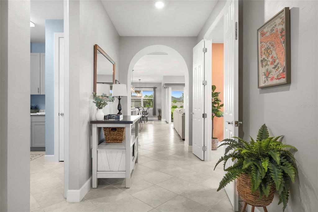 A bright hallway with tile floors leads through an arched doorway toward an open living area — 43047 PARKSIDE COURT, PUNTA GORDA, FL