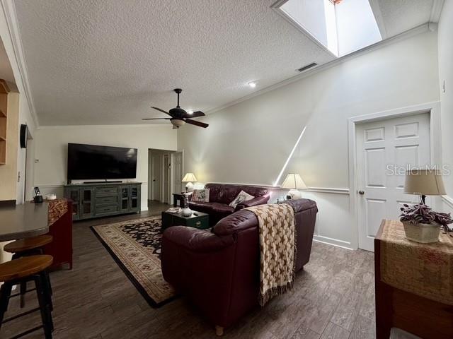 A living room features a stone fireplace, wood paneling, tile flooring, and a blue sofa — 155 WOODCUTTER LANE, PALM HARBOR, FL