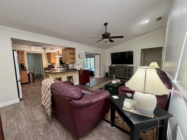 A living room with tile floors, a stone fireplace, and an open kitchen breakfast bar — 155 WOODCUTTER LANE, PALM HARBOR, FL