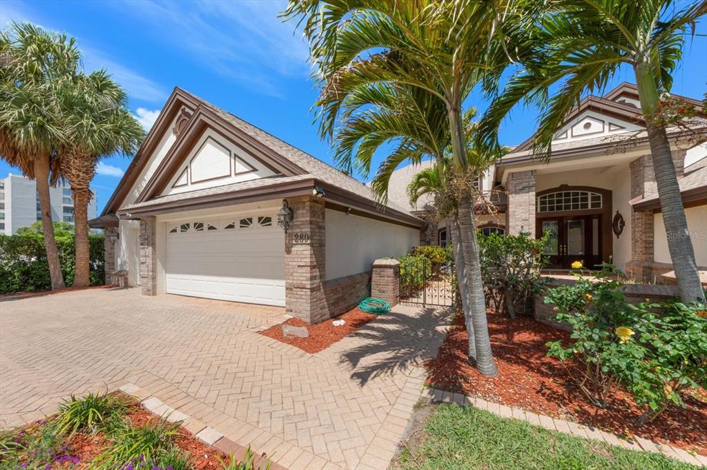 A single-story house with a brick-accented facade, a two-car garage, and palm trees — 280 BELLEVIEW BOULEVARD, BELLEAIR, FL