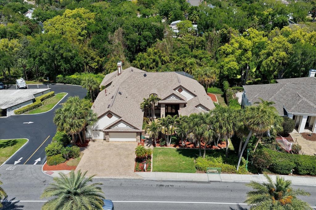 An aerial view shows a multi-story house with a shingled roof and a paved driveway — 280 BELLEVIEW BOULEVARD, BELLEAIR, FL