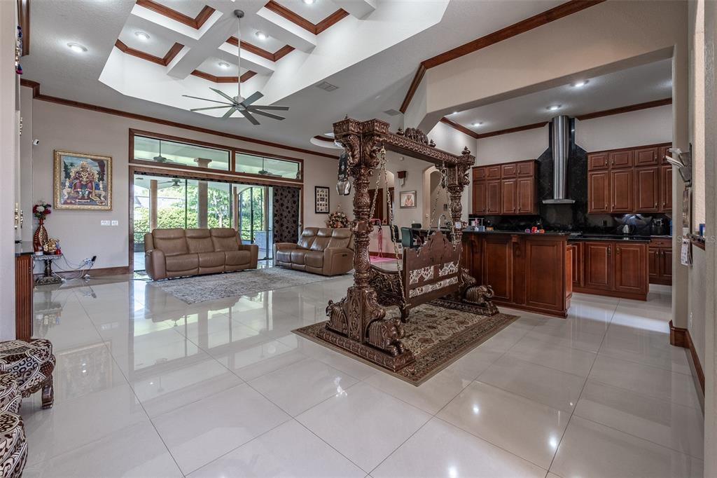 An open-concept living area features a large wooden swing, tile flooring, and a kitchen — 4222 SE 9TH AVENUE, OCALA, FL